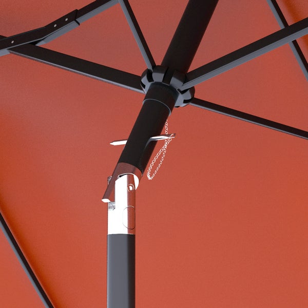 Großer terracottafarbener Sonnenschirm über einer Lounge-Sitzgruppe aus Polyrattan mit hellen Polstern auf einer Terrasse am Pool.