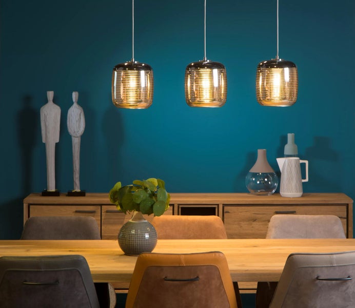 Esszimmer mit Holztisch, Stühlen und drei Pendelleuchten