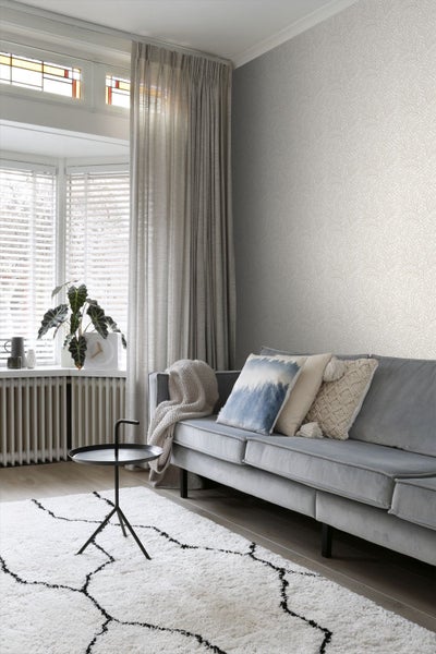 Wohnzimmer mit gemusterter Tapete, Sofa und Teppich