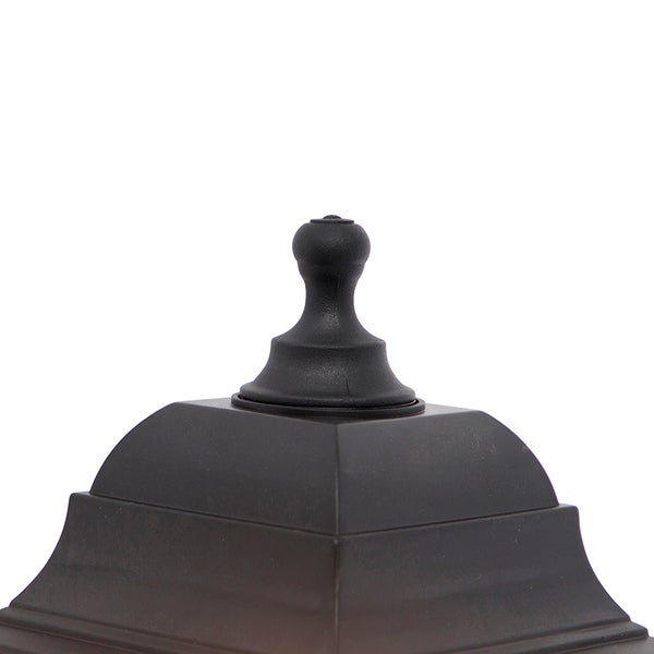 Detailansicht der schwarzen oberen Abdeckung einer Außenleuchte mit dekorativem Abschluss.