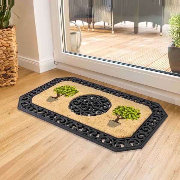 Fußmatte mit Baum-Motiv und dekorativem Rahmen vor einer Terrassentür