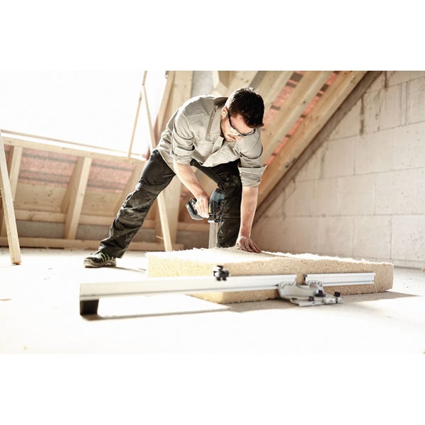 Handwerker schneidet Dämmstoff mit einer Säge auf einer Baustelle