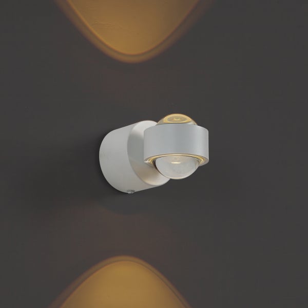 Moderne Wandleuchte mit zwei runden Glaslinsen, die das Licht kegelförmig nach oben und unten abgibt.