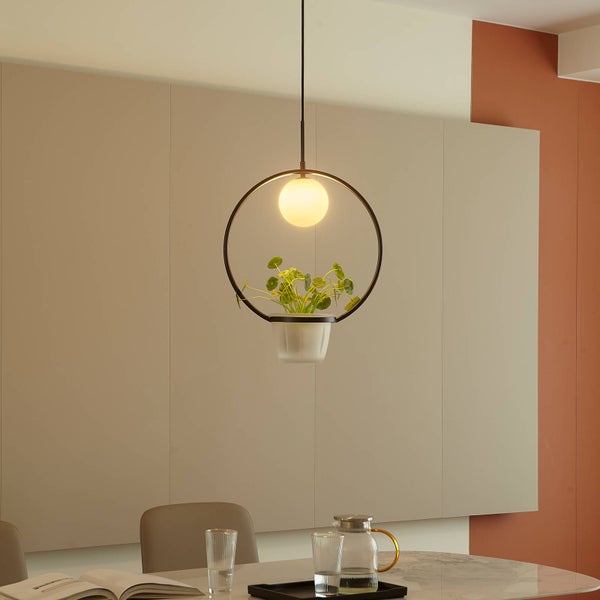 Hängeleuchte mit Pflanzenbehälter über einem Esstisch