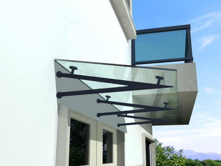 Glasvordach mit Metallträgern an einer Hauswand