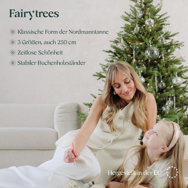 Fairy Trees Kunstweihnachtsbaum in Nordmanntannenform mit Buchenholzständer und geschmückt in einem weihnachtlich dekorierten Wohnraum.