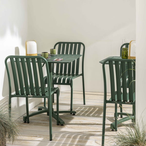 Grünes Gartenmöbel-Set aus Metall mit Lattenstühlen und Tischen auf einer hellen Holzterrasse.