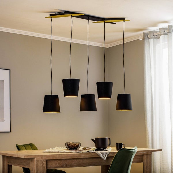 Fünfflammige Pendelleuchte mit schwarzen Stoffschirmen in verschiedenen Höhen über einem Holztisch in einem modernen Esszimmer.