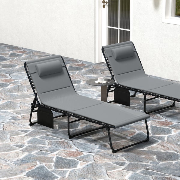 Gemütliche Gartenecke mit rundem Bistrotisch aus Metall, zwei Holzlaternen, Polyrattan-Sessel und Efeu an einer weißen Holzwand.
