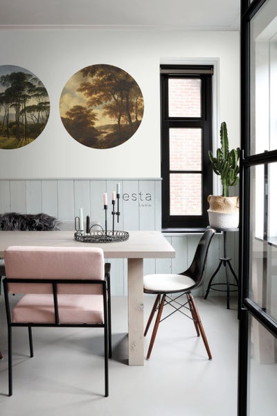 Esszimmer mit Esstisch, Stühlen, runden Wandbildern und Kaktus