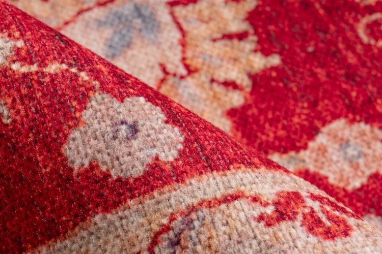 Nahaufnahme eines roten Teppichs mit orientalischem Blumenmuster und weicher Textur.