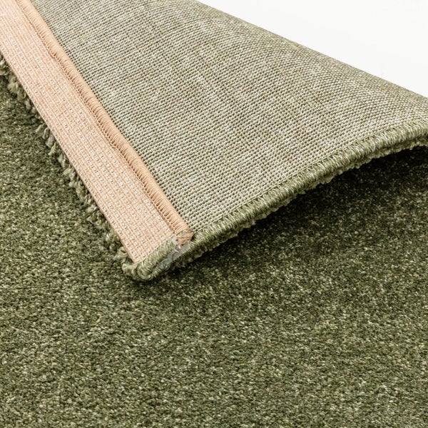 Grüner Hochflor-Teppich mit strukturierter Oberfläche und sichtbarer Rückseite.