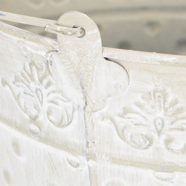Detailaufnahme eines Metall-Pflanztopfes mit geprägtem Muster und Vintage-Finish am Rand und Griffansatz.