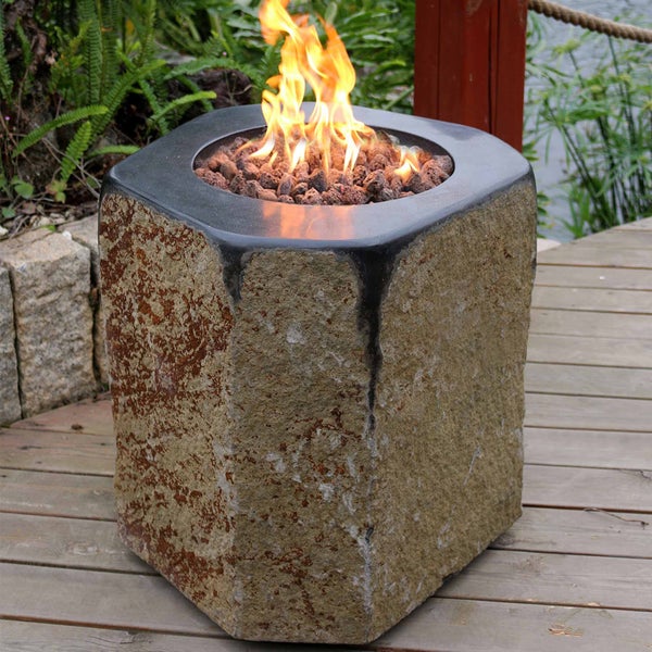 Sechseckige Feuerstelle in Naturstein-Optik mit Lavasteinen und brennender Flamme auf einer Holzterrasse.