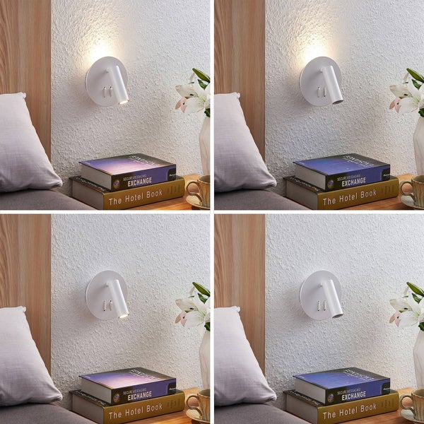 Moderne weiße Wandleuchte mit schwenkbarem Lesespot und indirektem Licht, montiert im Schlafzimmer über einem Nachttisch mit Büchern.