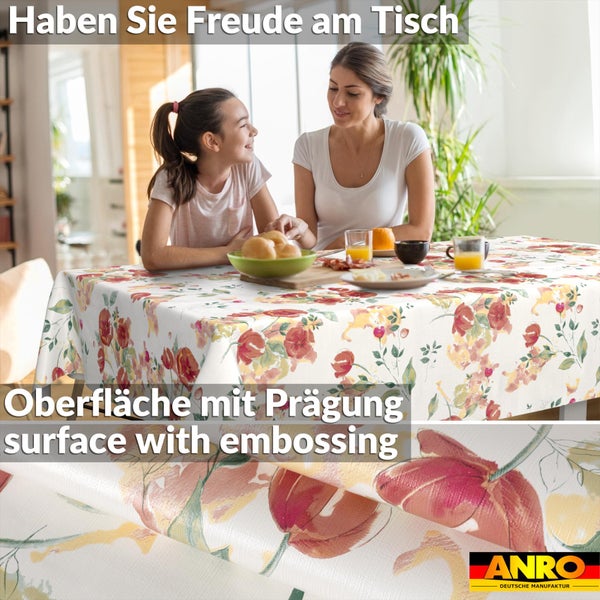 Abwaschbare Tischdecke mit Blumenmuster und geprägter Oberfläche in einer Wohnszene am Esstisch. ANRO Logo.