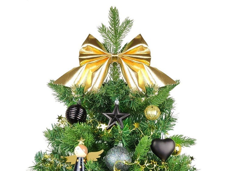 Weihnachtsbaumspitze mit einer glänzenden Schleife als Christbaumschmuck auf einer künstlichen Tanne.