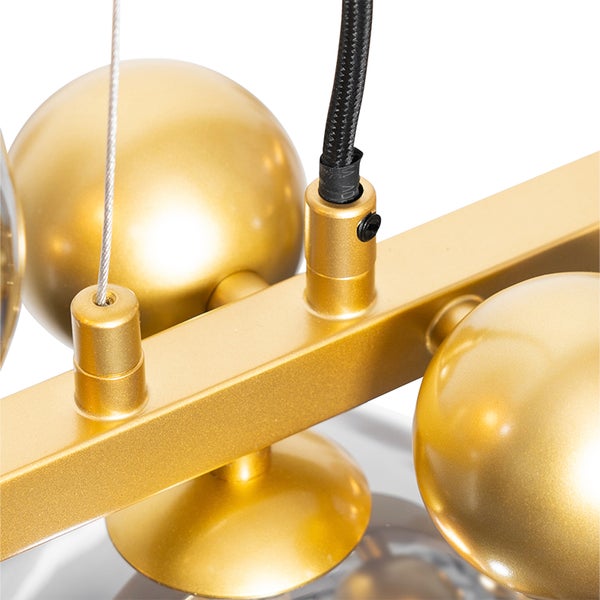 Detailansicht einer goldenen Hängeleuchte mit mehreren Kugeln