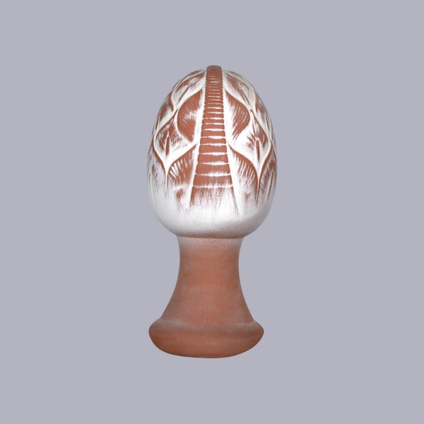 Zaunhocker Artischocke aus Terrakotta mit weißem Finish auf einem Sockel.