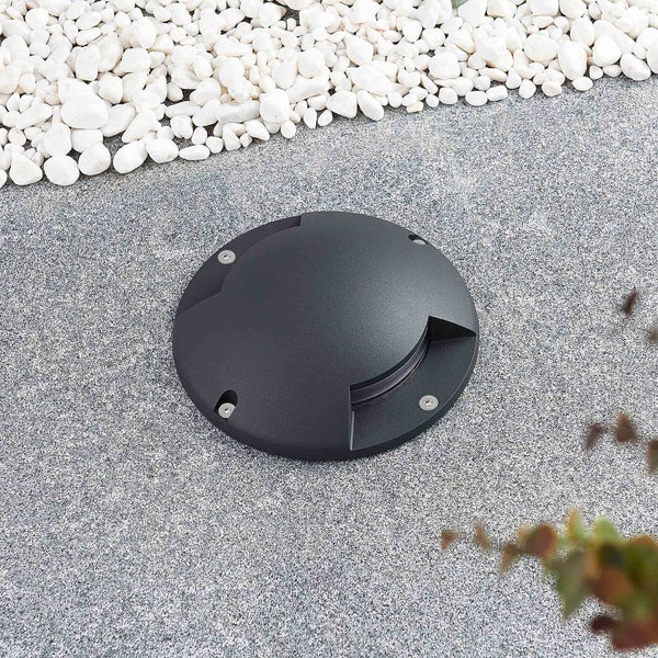 Runde Bodenleuchte für den Außenbereich aus Metall in Anthrazit, installiert auf einer Steinfläche.