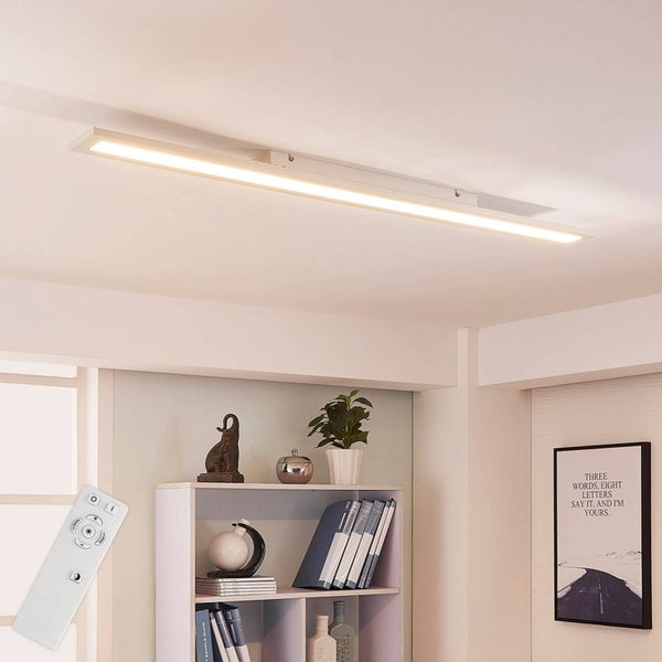 Moderne, längliche LED Deckenleuchte in Weiß mit Fernbedienung, montiert an der Zimmerdecke über einem Regal im Wohnbereich.