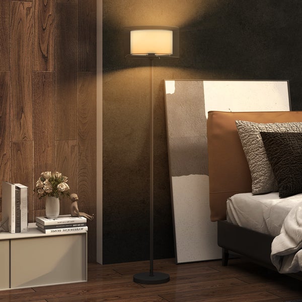 Wohnzimmer mit Stehlampe, Bett und Dekoration