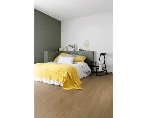 Schlafzimmer mit Bett, Schaukelstuhl und hellem Holzboden