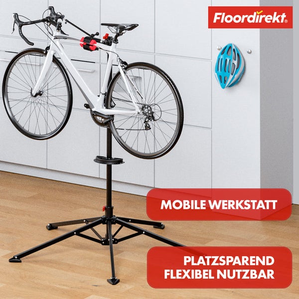 Fahrrad auf Montageständer in Werkstatt, Helm an Wand