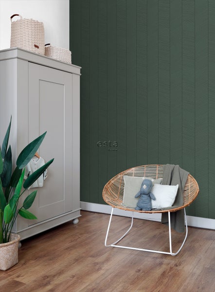 Kinderzimmer mit dunkelgrüner Tapete mit Pfeilmuster, grauem Kleiderschrank und Rattansessel.