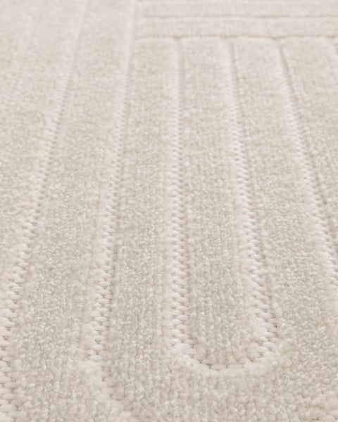 Detail einer weichen Badematte aus Textil mit gestreifter Struktur.