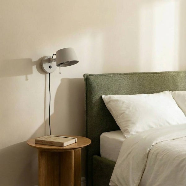 Wandleuchte über Nachttisch neben Bett im Schlafzimmer