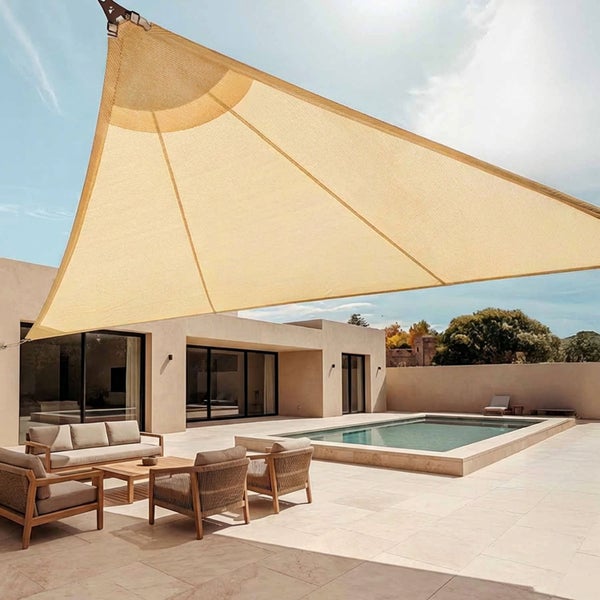 Dreieckiges Sonnensegel über einer modernen Terrasse mit Pool, Sitzmöbeln und hellem Steinboden.