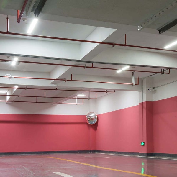 Innenraumaufnahme eines Parkhauses mit Leitungen und Verkehrsspiegel