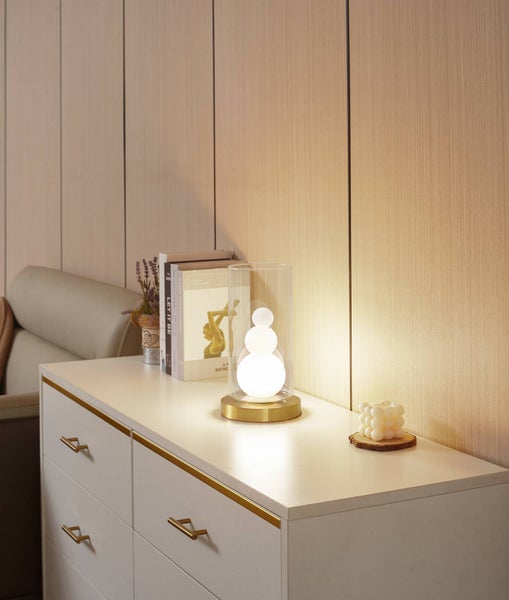 Dekorative Tischlampe auf einem Nachttisch mit Schubladen