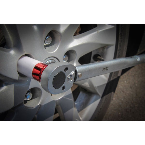 Szene mit Person, die ein Autorad mit Werkzeug wechselt, inklusive Radkreuz und Drehmomentschlüssel