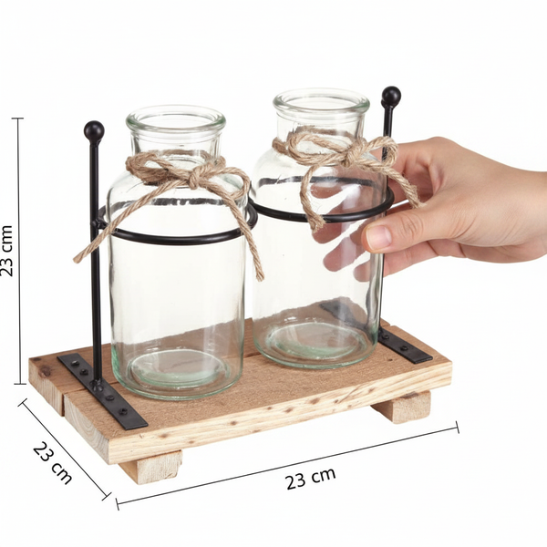Zwei Glasvasen auf einem Holzpodest mit schwarzem Metallrahmen und Juteschleifen, 23 Zentimeter hoch, 23 Zentimeter breit, 23 Zentimeter tief.