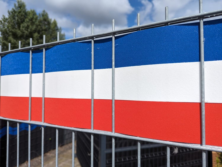 Zaunblende mit drei horizontalen Streifen am Maschendrahtzaun