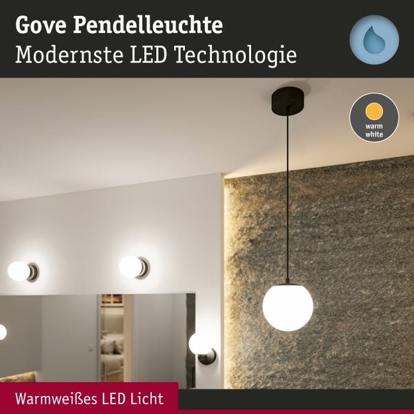 Moderne Gove Pendelleuchte mit weißem Kugelschirm und warmweißem LED-Licht in einem hellen Badezimmer mit Natursteinwand und Spiegel.
