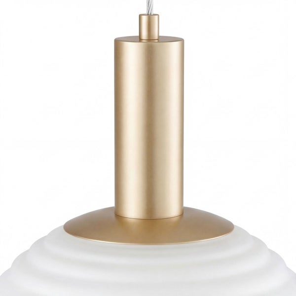 Nahaufnahme einer Pendelleuchte mit goldfarbener zylindrischer Metallfassung und weißem geriffeltem Lampenschirm.