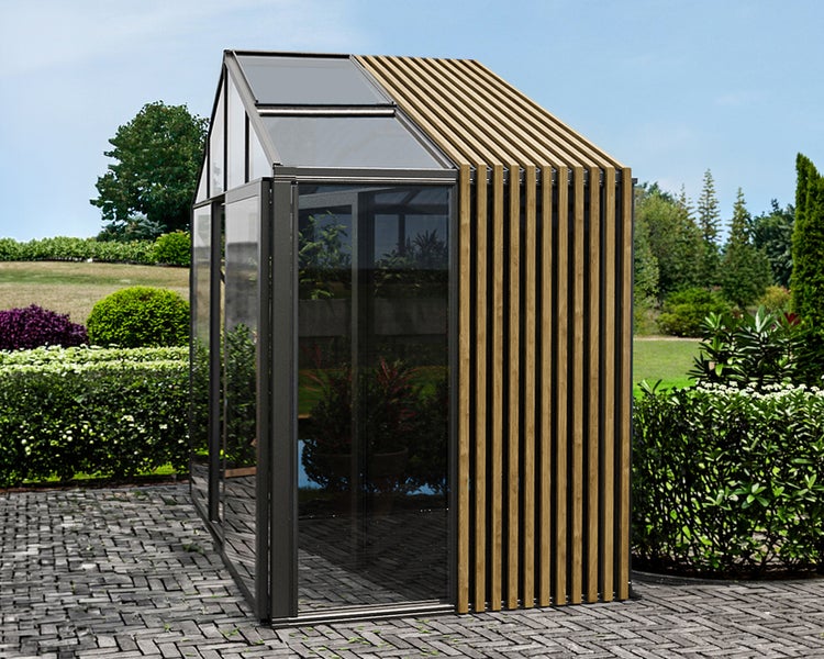 Modernes Gewächshaus aus Aluminium mit einer Seite aus Glas und einer Seite aus vertikalen Holzlamellen, auf gepflastertem Gartenboden.