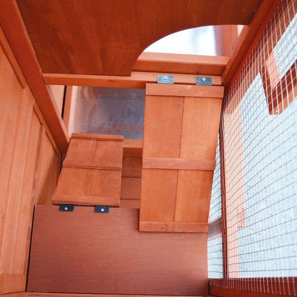 Innenansicht eines Kleintierstalls aus Holz mit Rampen zwischen den Ebenen und seitlichem Drahtgitter.