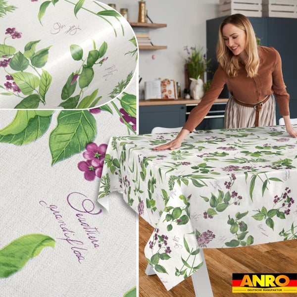 Abwaschbare Tischdecke mit botanischem Muster aus Blättern und Blüten auf einem Küchentisch, ANRO Deutsche Manufaktur Logo.