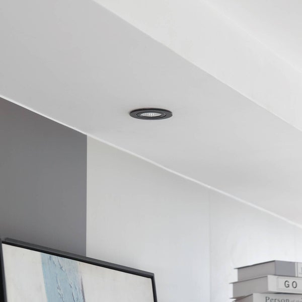 Einbaustrahler in einer weißen Decke in einem hellen, modern gestalteten Raum.