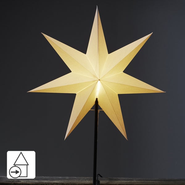 Dekoratives Wohnzimmer mit beleuchteten Papiersternen unterschiedlicher Größe als Weihnachtsdekoration.