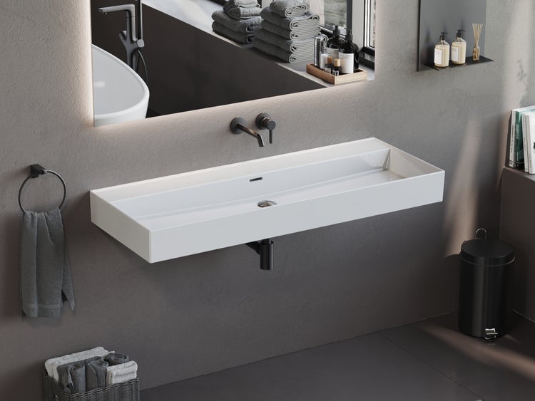 Modernes Badezimmer mit einem weißen Aufsatzwaschtisch und dunklen Armaturen.