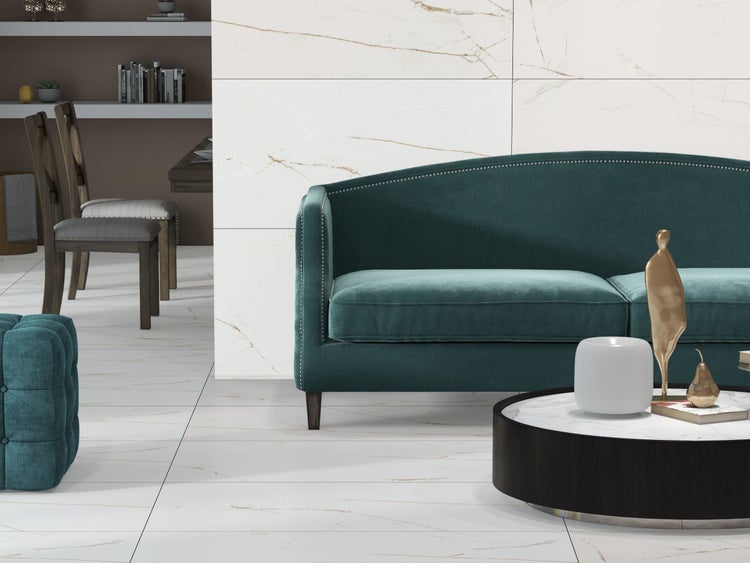 Wohnraum mit Sofa, Sessel und Fliesenboden in Marmoroptik