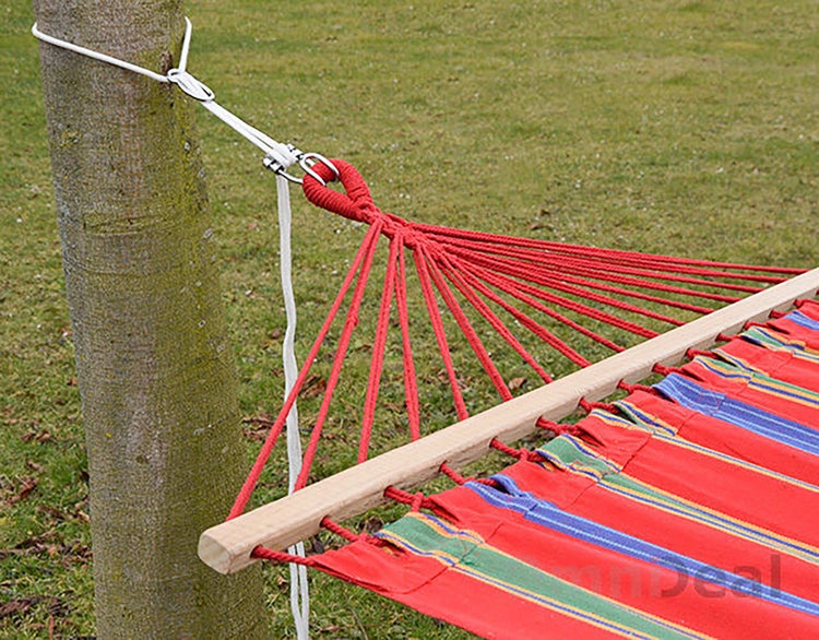 Befestigung einer Hängematte mit Holzspreizstab und Seil an einem Baumstamm im Garten