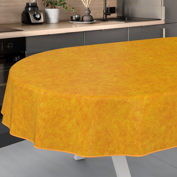 Gelbe, runde Wachstuch-Tischdecke auf einem Tisch in einer Küche