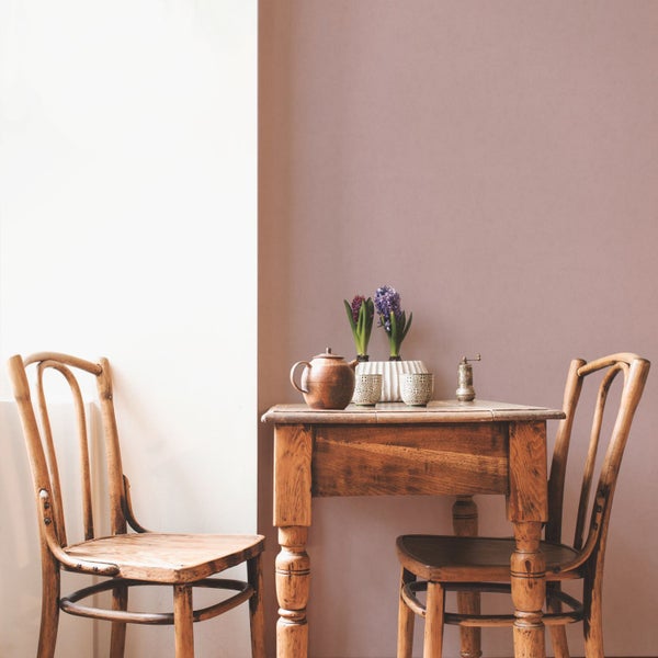 Helles Zimmer mit Holztisch, zwei Stühlen und Dekoration