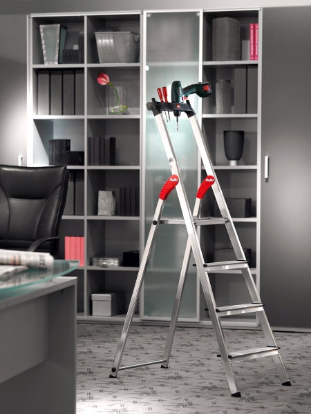 Aluminium-Haushaltsleiter mit vier Stufen und Ablageschale vor einem Regal